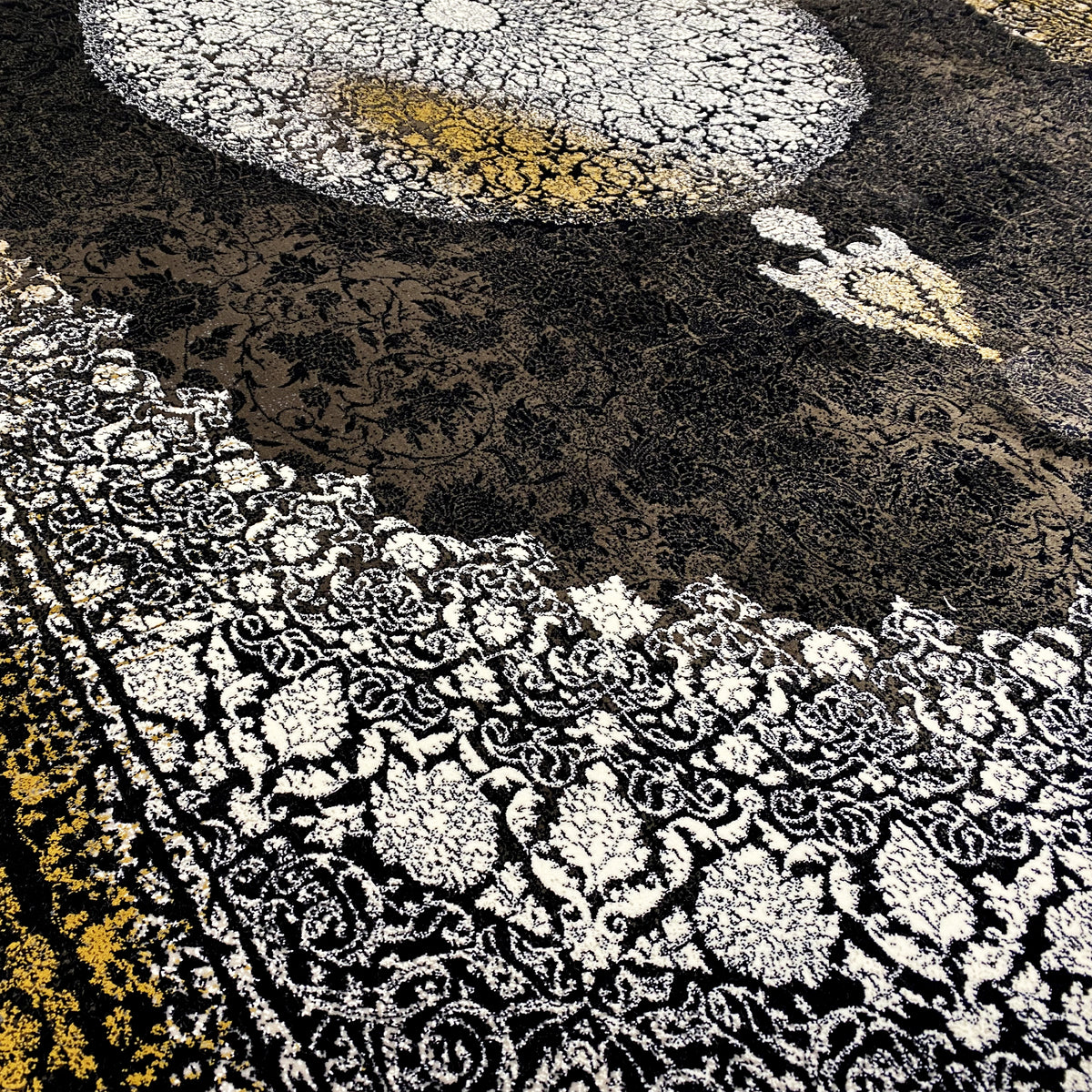 Carpet detail: black area with a silver ornamental carpet and a golden-yellow stripe