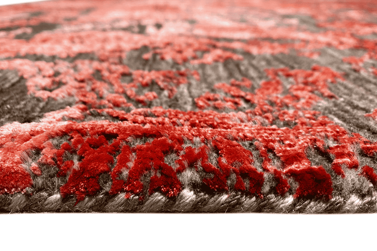 Close-up of the carpet pile: Red pattern with a gray base and dense texture