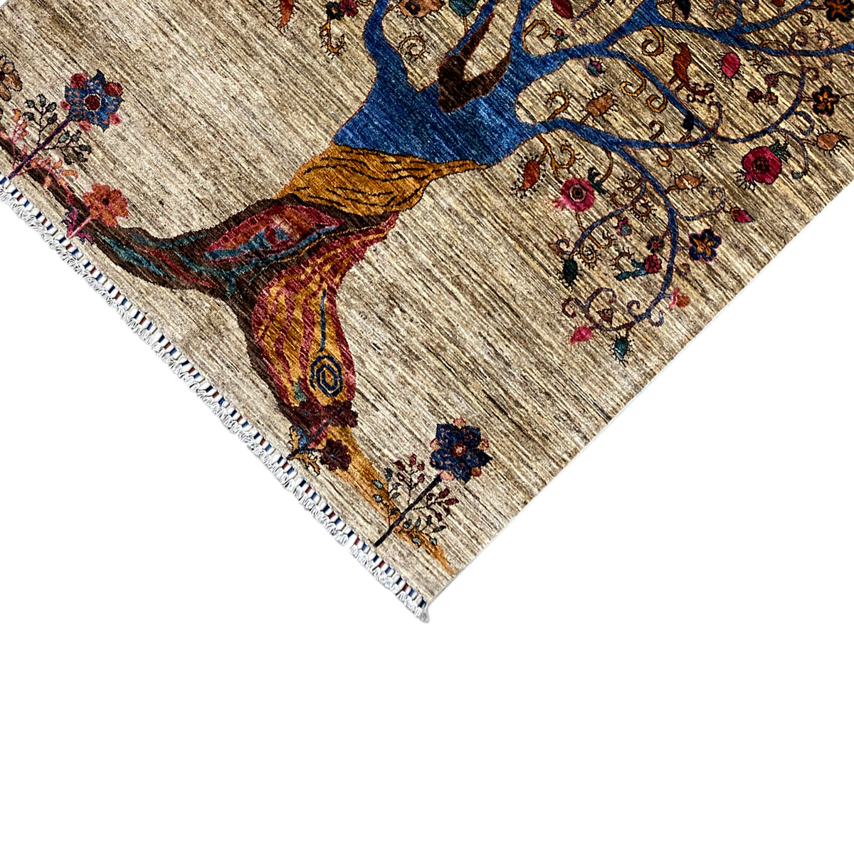 Close-up of the edge: beige rug with fringe and a tree motif in blue and orange