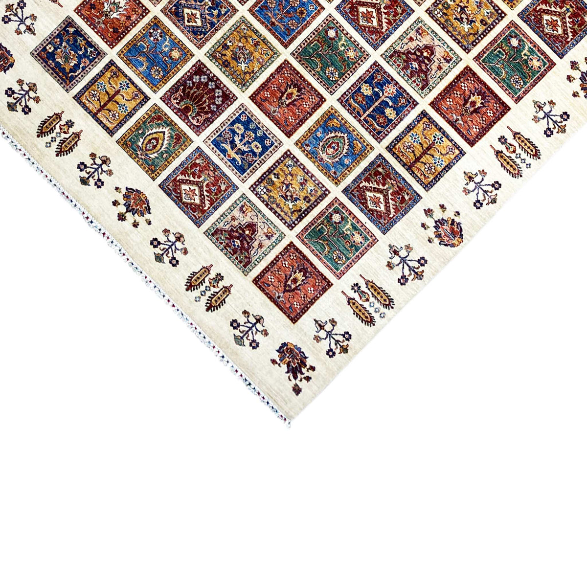 Wool rug edge detail: tile pattern and small floral ornaments on a cream-colored background