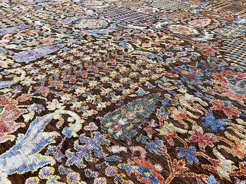 Carpet surface with a fine, multicolored ornamental pattern and textured pile.