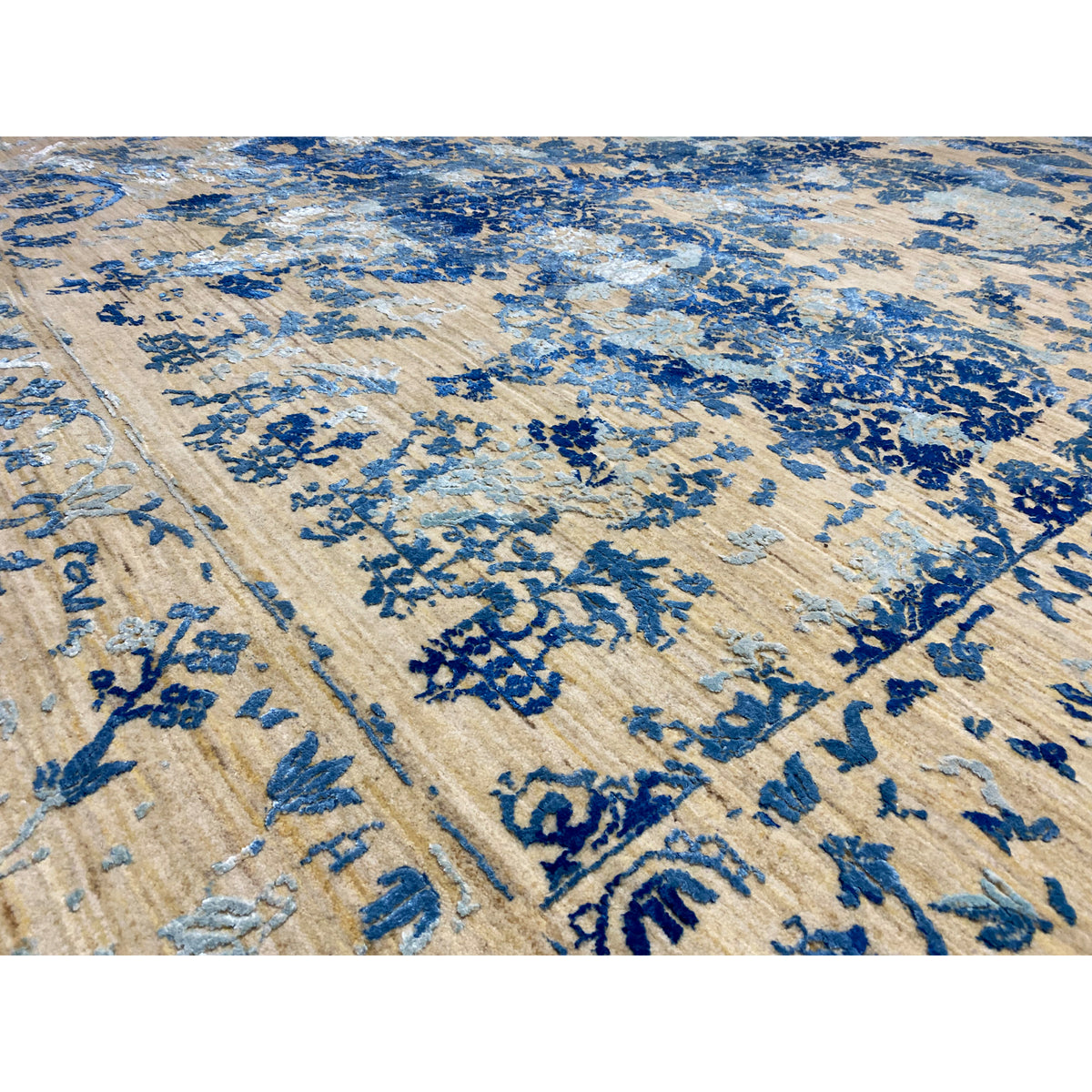 Close-up: blue ornamental detail on a beige carpet background with a bordered trim