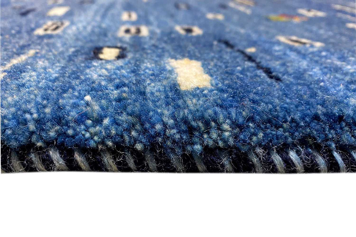 Close-up: blue Gabbeh rug with pile and side edge/fringe