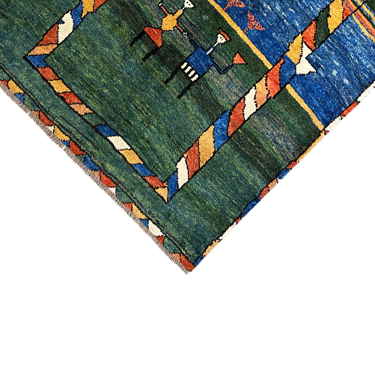 Gabbeh rug corner close-up: green patterned field with fringes and a colorful border