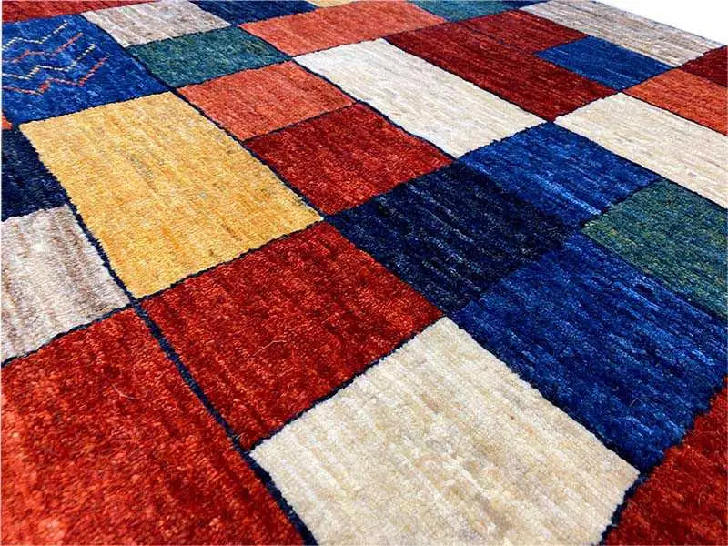 Gabbeh rug: detailed view of the diamond patterns in red, blue, yellow, cream and green