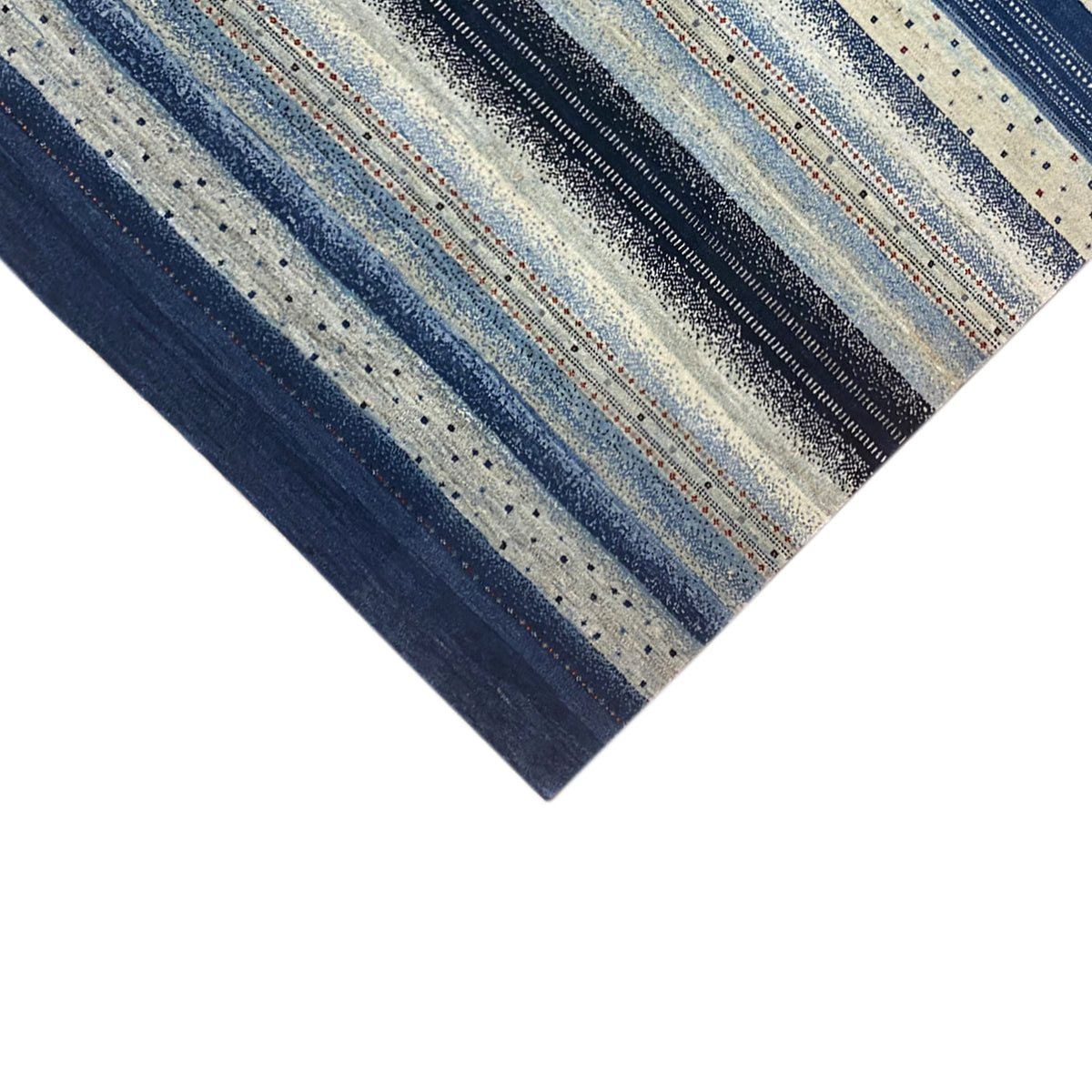 Close-up: stripes and dots on a Gabbeh rug, predominantly in blue and cream