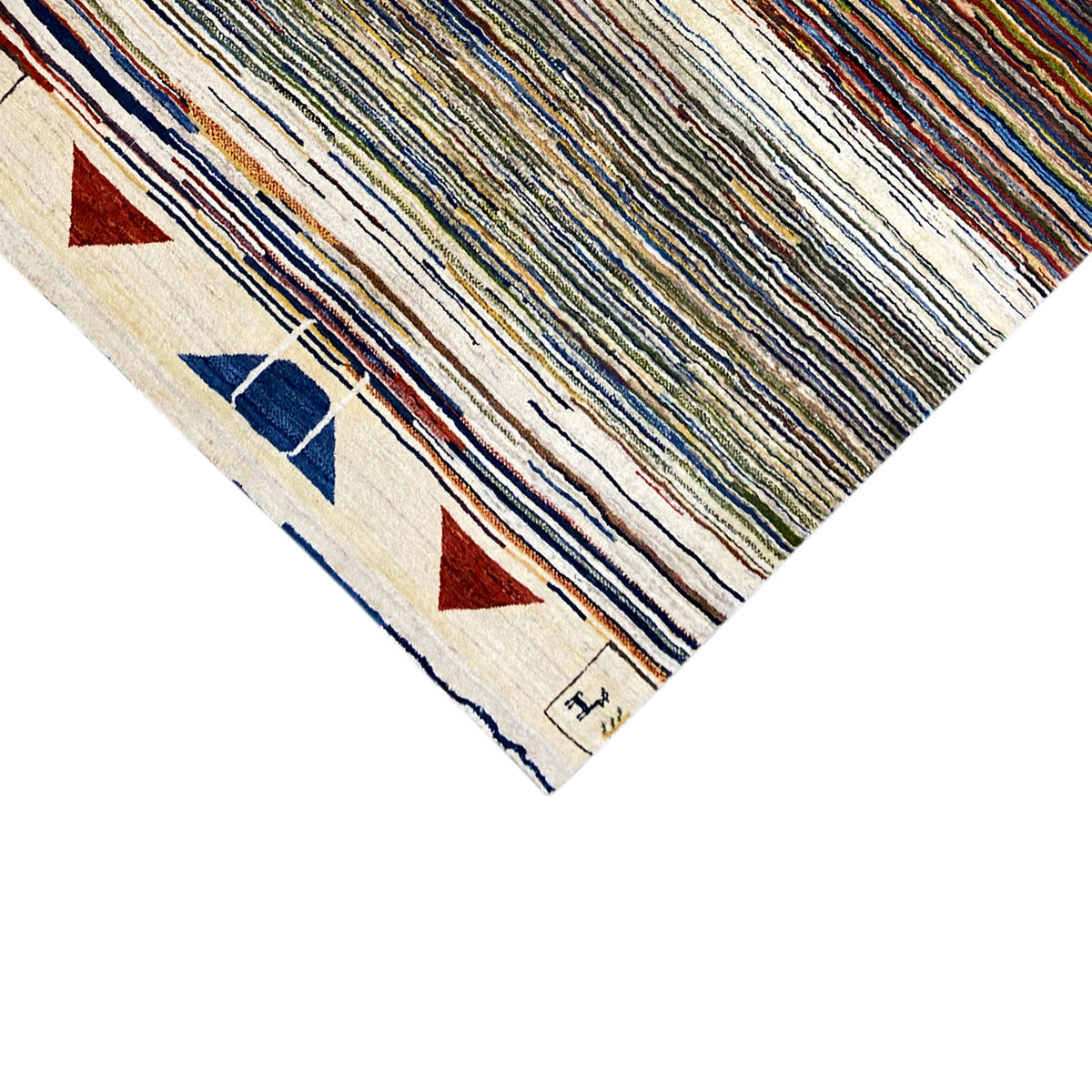 Corner of the Gabbeh rug: light border with triangular and block ornaments, multicolored stripes
