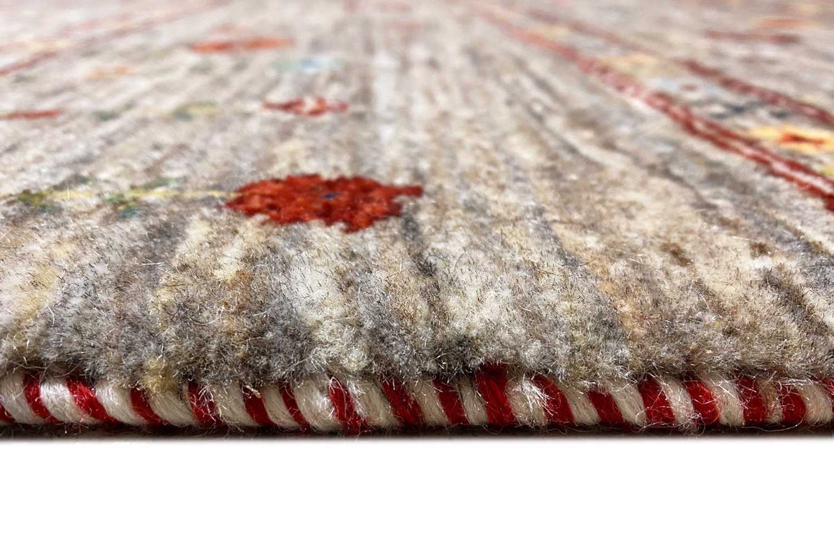 Close-up of the edge of a Gabbeh rug: short fringes in red and brown