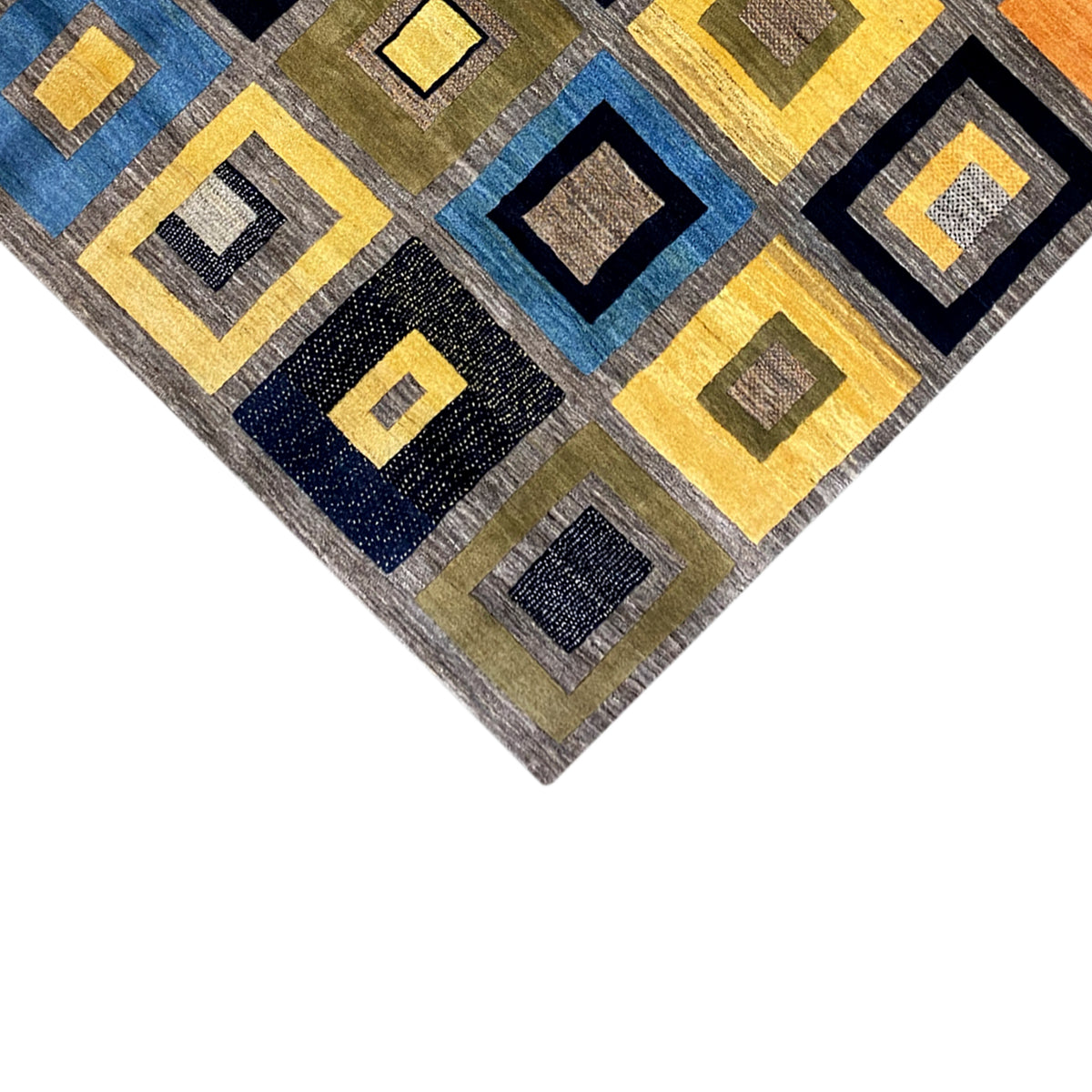 Gabbeh rug detail of a corner: square pattern in blue, yellow, gray, and black.