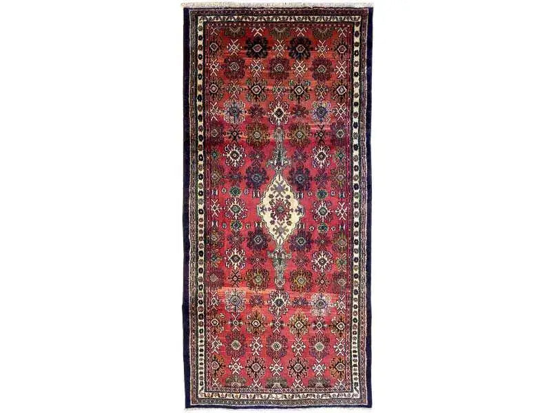 Oriental rug with a red field and blue border, featuring a central medallion