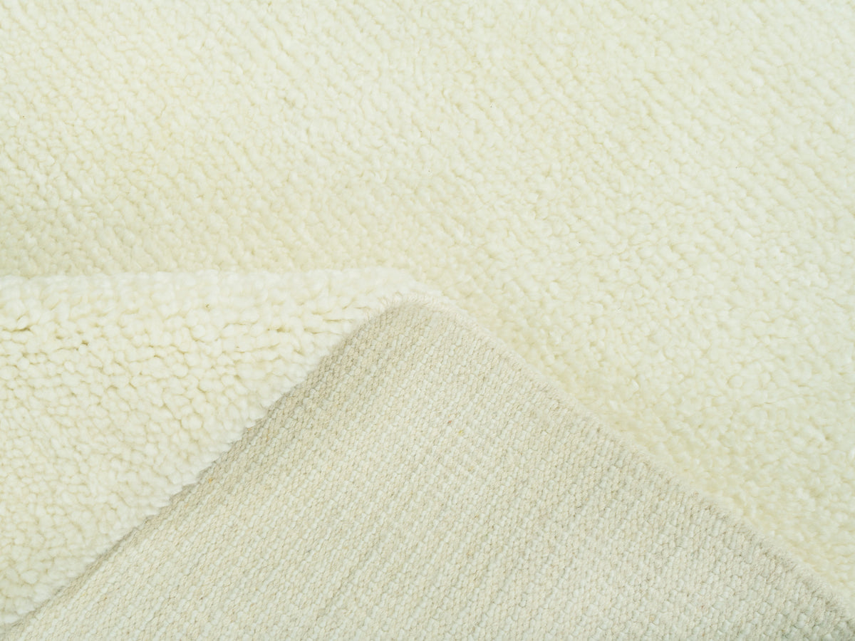 Teppichfläche in Detailansicht mit beiger, flauschiger Struktur und feiner Relieftextur