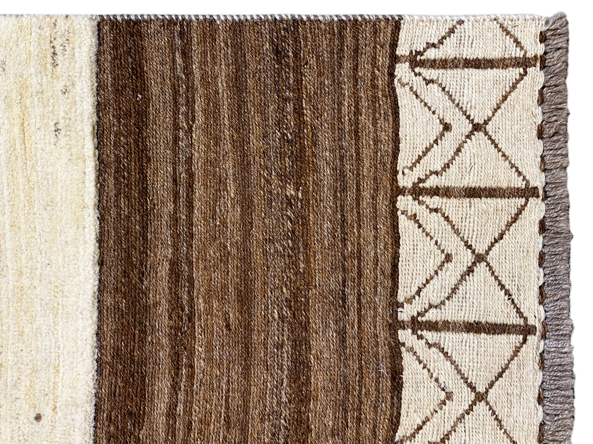 Gabbeh-Teppich Randdetail mit dunklem braunem Streifen, beigem Geometrie-Muster und Fransen
