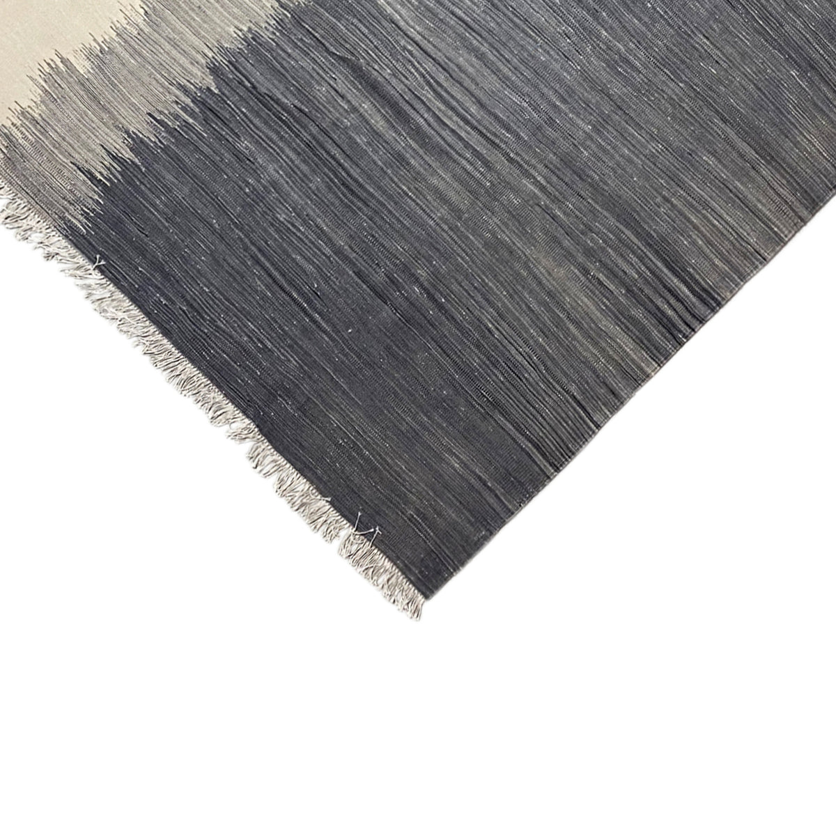 Kilim rug corner: dark field, light accents, fine line texture, fringes