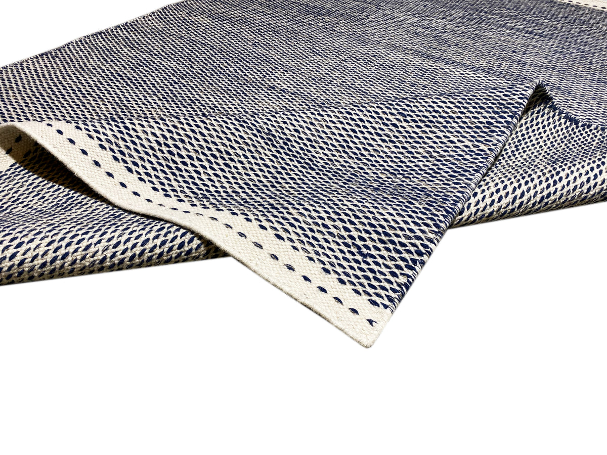 Kelim-Teppich mit sichtbarer Kante und gedrehtem Randdetail in Blau