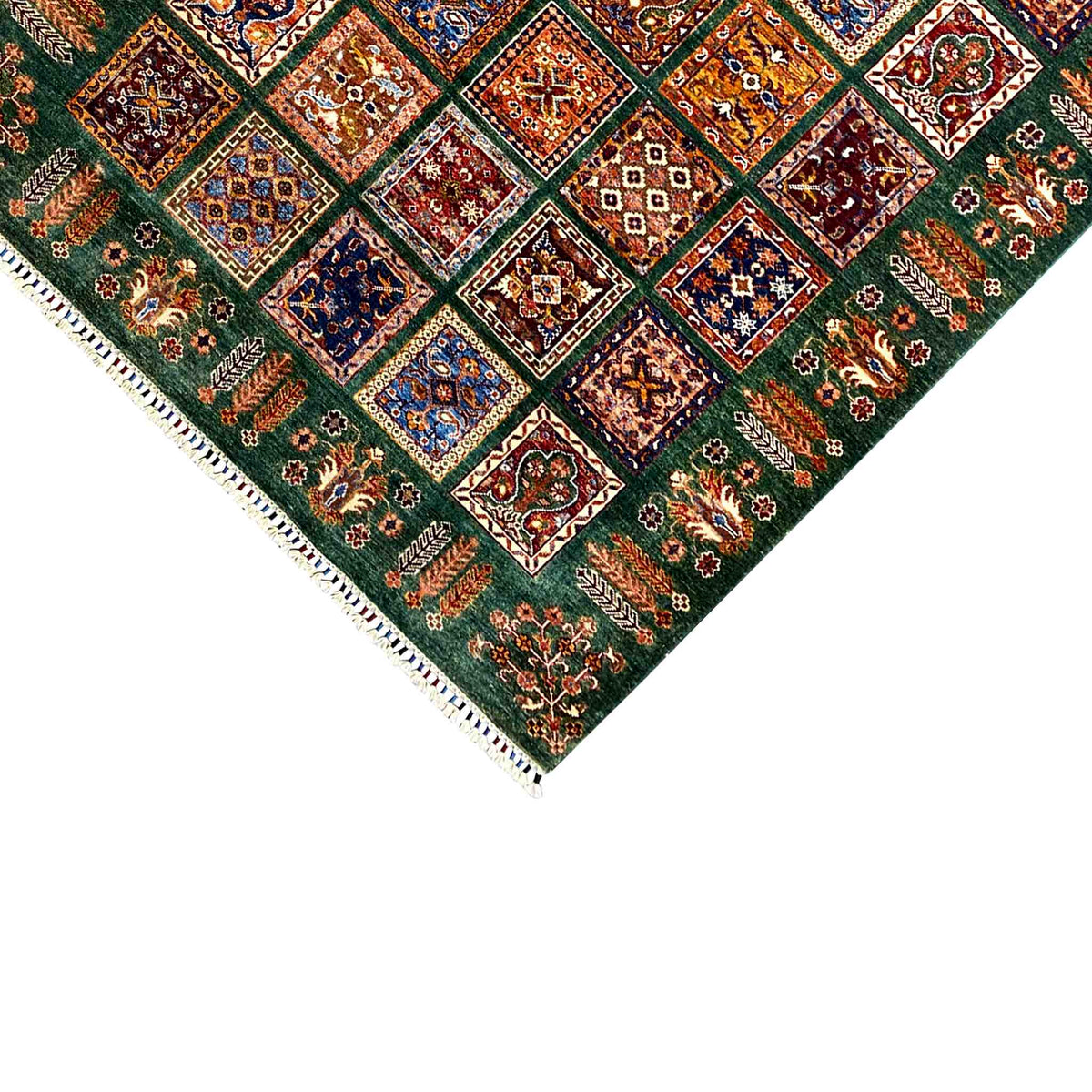 Hand-knotted Khorjin rug corner detail with fringe and colorful square pattern on green