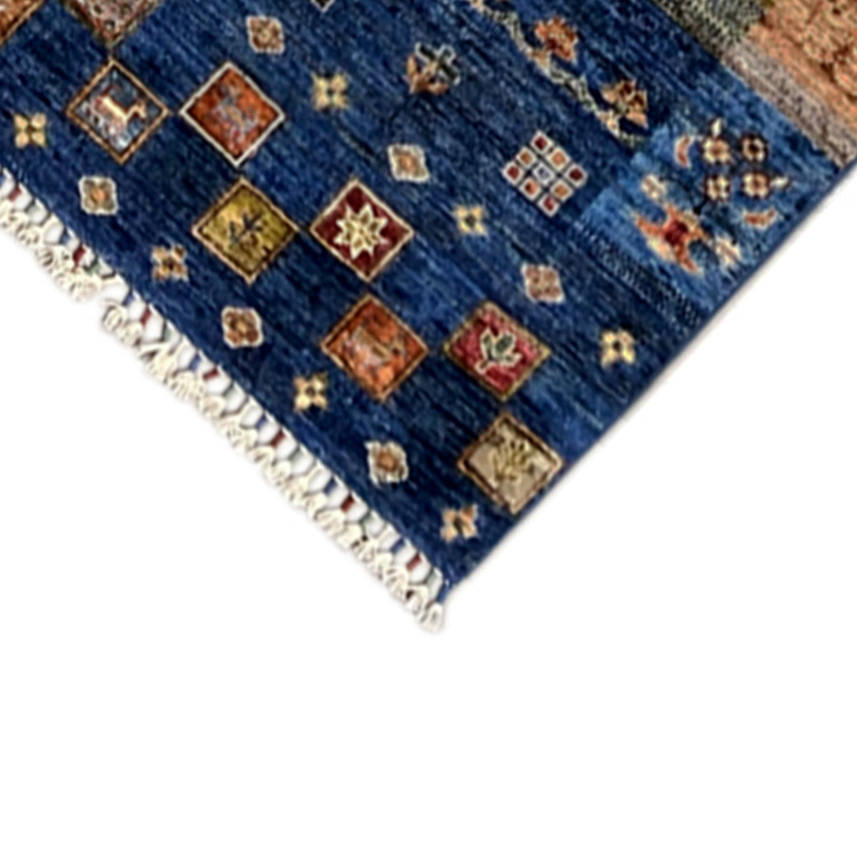 Detail on the edge: colorful patchwork squares in the blue field with white fringes