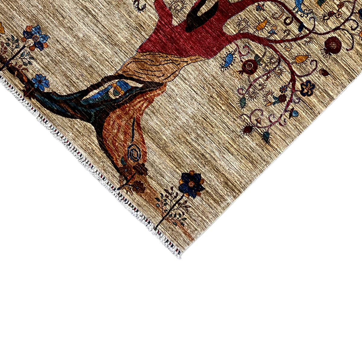 Close-up of a rug corner with a tree of life, bird motif, and colorful embroidered details