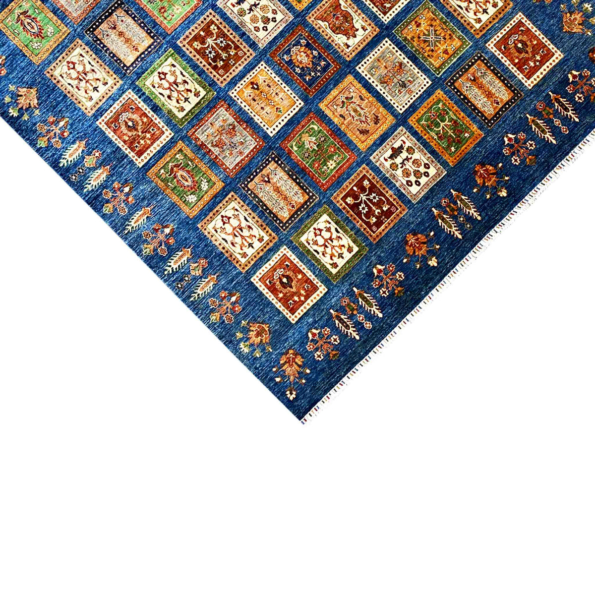 Blue rug with colorful square tiles and fringes, diagonal view
