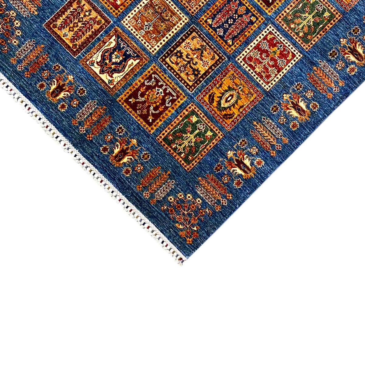 Blue Khorjin corner rug with colorful square patterns, border details, and white fringes