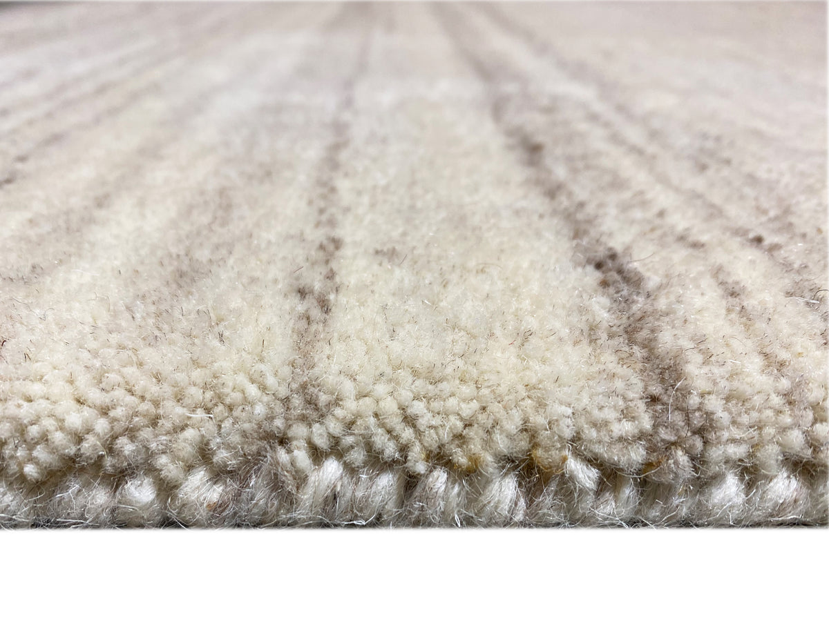 Teppichunterkante im Detail: weiche Florstruktur mit beigen und grauen Fleck-Übergängen