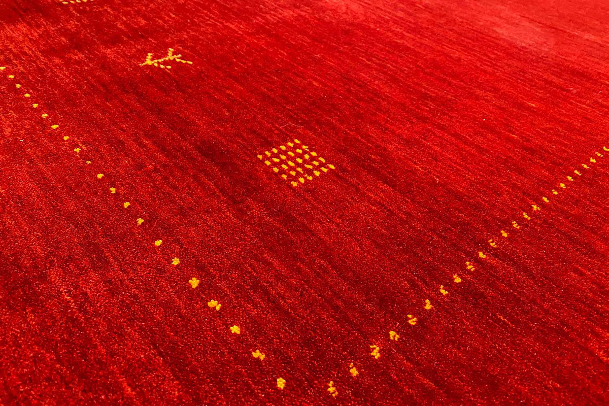 Red Gabbeh rug with yellow ornamental dots and a fine woven texture