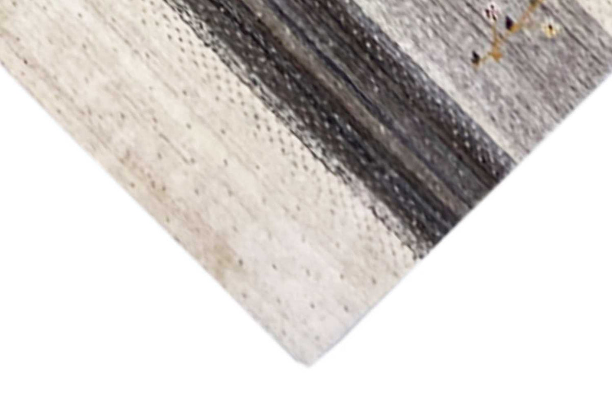Gabbeh rug corner with a dark border strip and beige pile