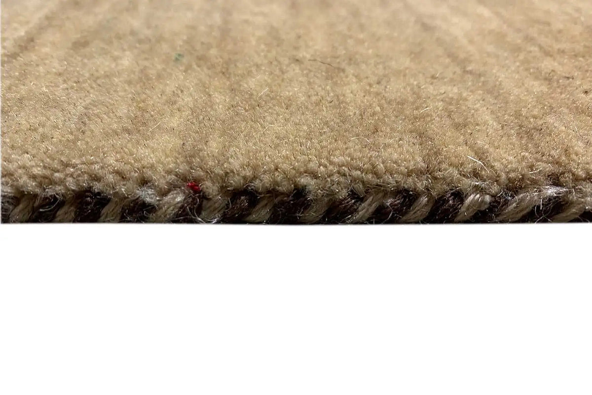 Gabbeh rug edge with dense pile and brown fringes, yarn texture visible