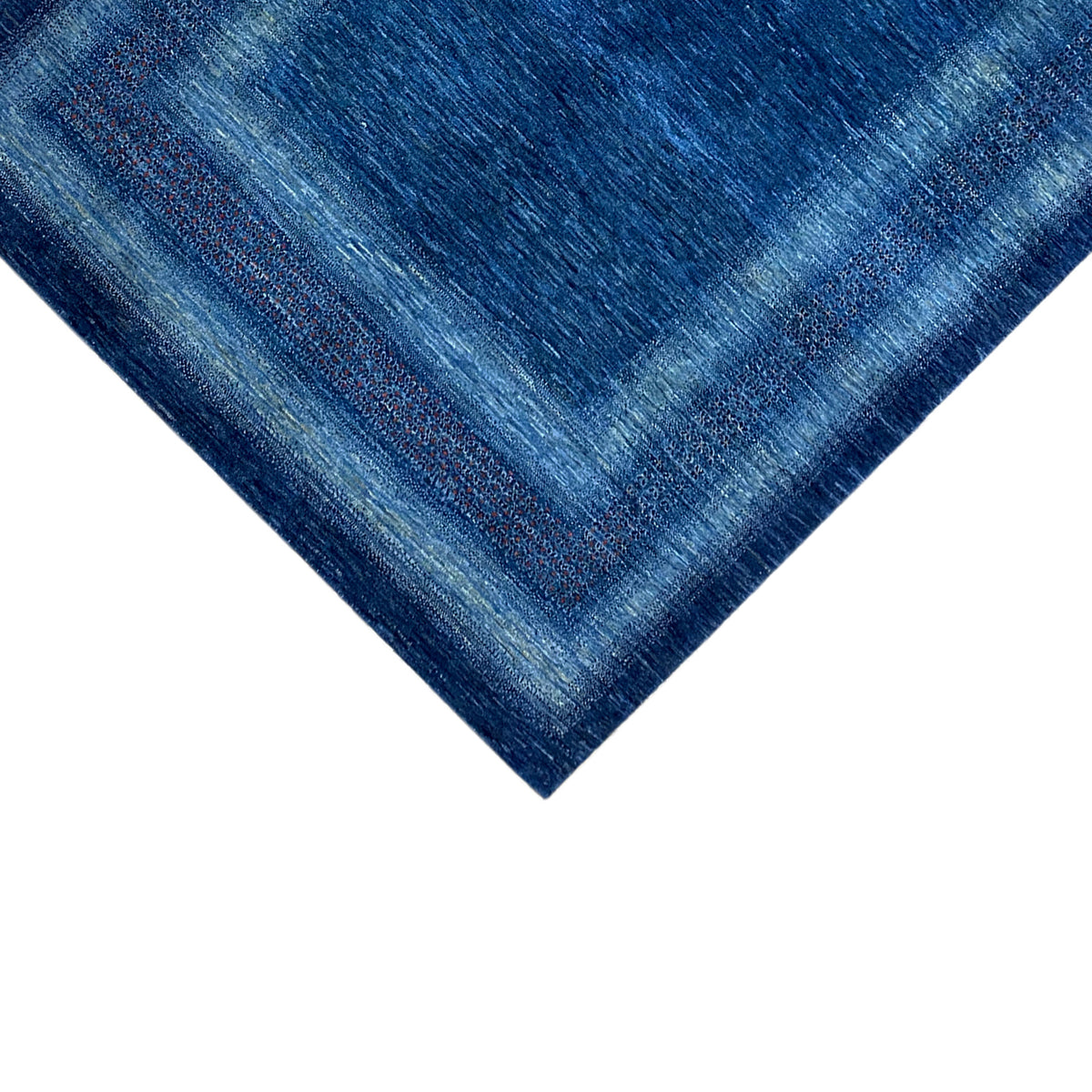 Carpet corner: blue border pattern with flowing transitions, fine woven texture