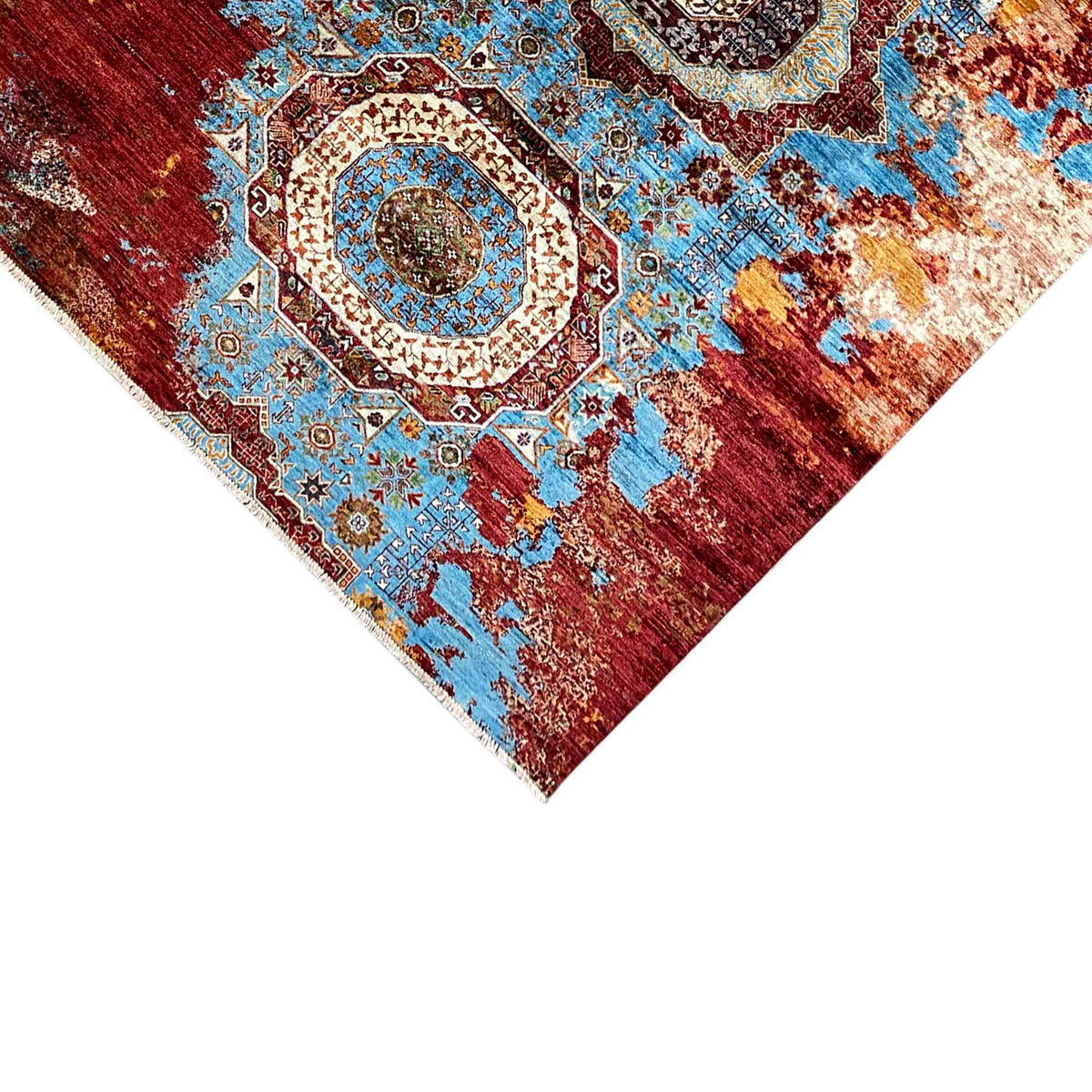Corner detail of the rug: border and medallion pattern in blue, red, and cream