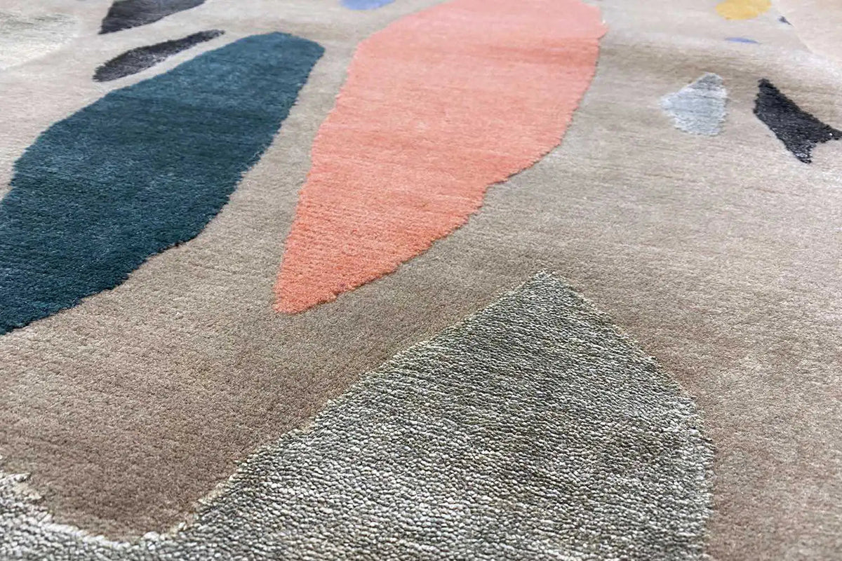 Rug surface with a rough texture and abstract color blocks in blue and coral