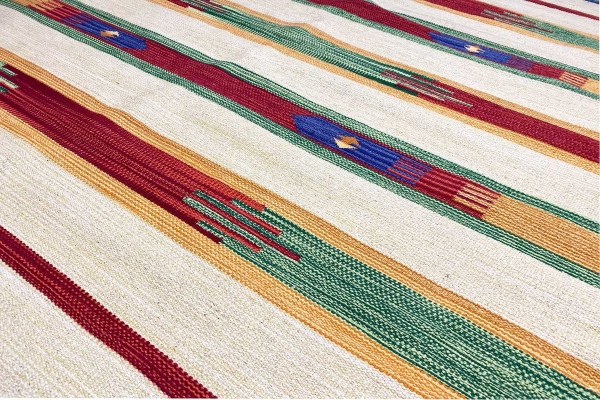 Close-up of Samak kilim rug: woven stripes in green, red, and blue on a light background
