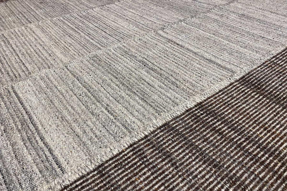 Detail of the carpet surface: fine woven texture in light gray with dark stripes