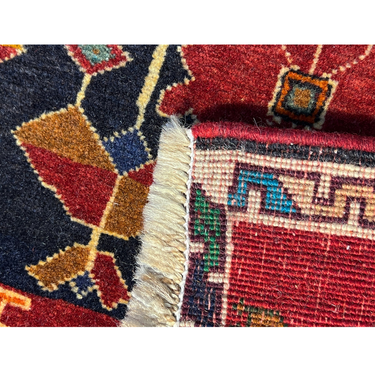 Poshti rug detail at the edge: woven border with fringes, red and dark blue areas