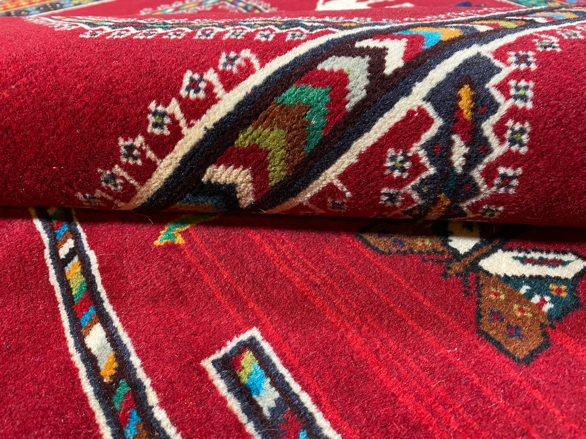 Nahaufnahme: Bordüre und Faltkante, roter Grund mit mehrfarbigen Ornamenten