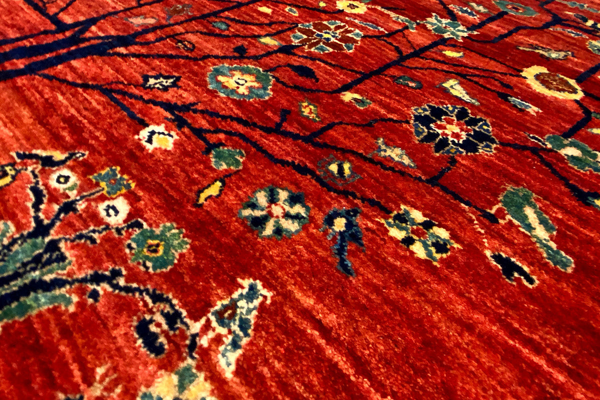 Close-up of a Qashqai rug: red pile with colorful floral motifs