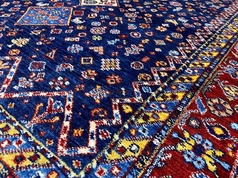 Close-up: blue carpet fabric with a colorful geometric pattern