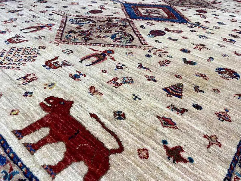 Close-up of patterned carpet: red animals, blue border lines, and fine ornamental details