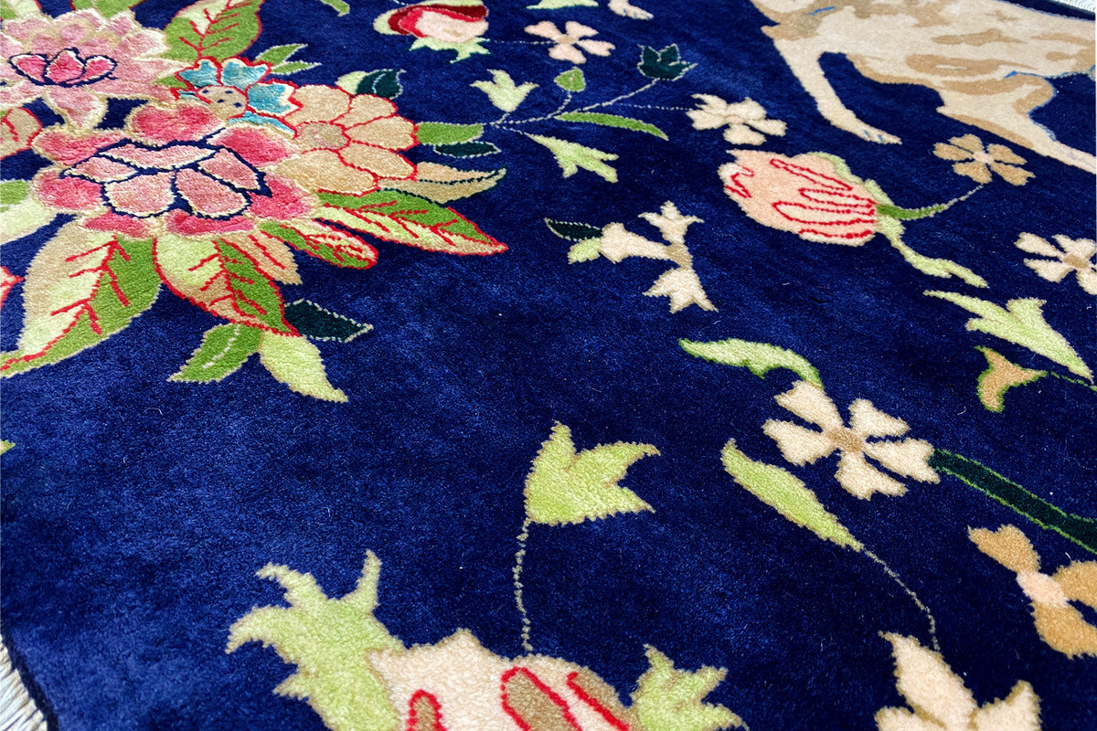 Close-up of a carpet pattern with colorful flowers and animals on a blue background