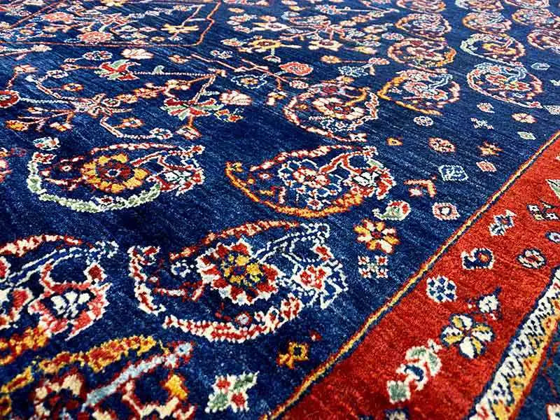 Qashqai exclusive oriental rug close-up: blue patterned field with red accents