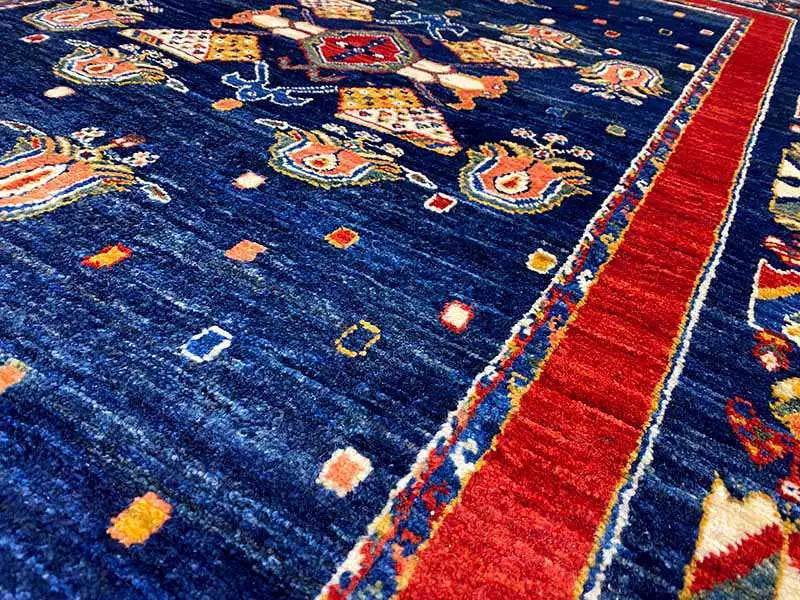 Carpet pile detail: dark blue base with a red side band and colorful motifs