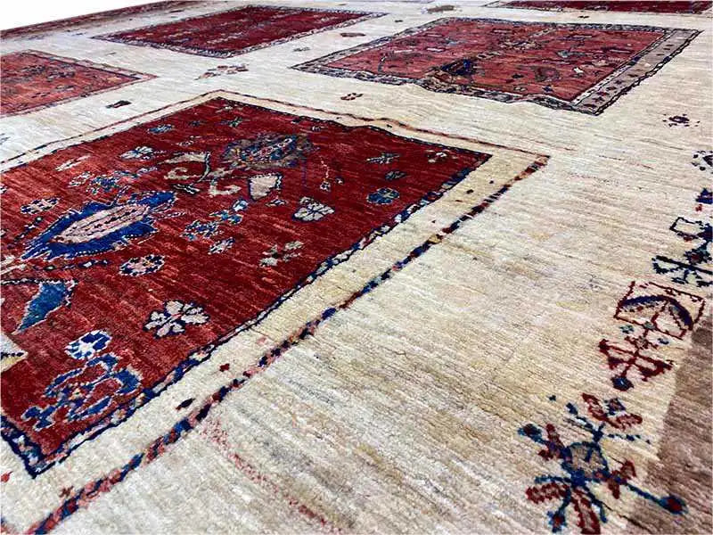 Close-up of an Oriental rug: beige pile with red and blue decorative elements