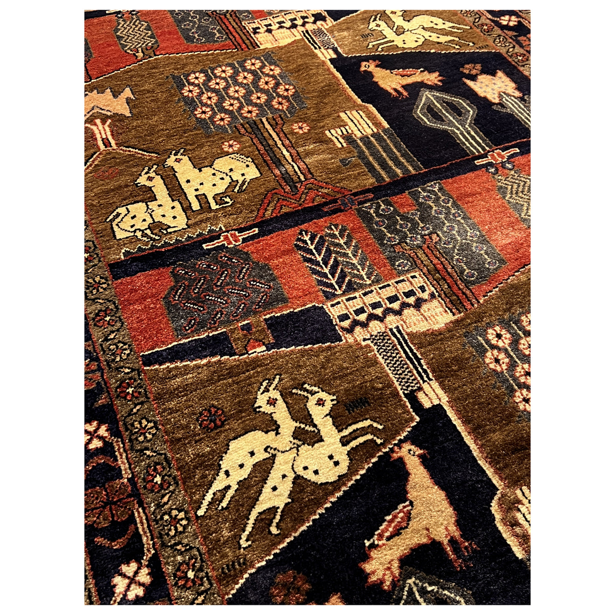 Close-up: Oriental rug with animal motifs, patchwork squares, and decorative border