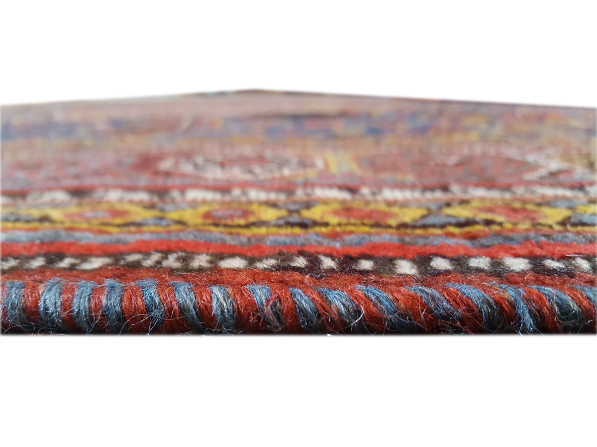 Rug edge with fringes and a multicolored border in blue and rust tones