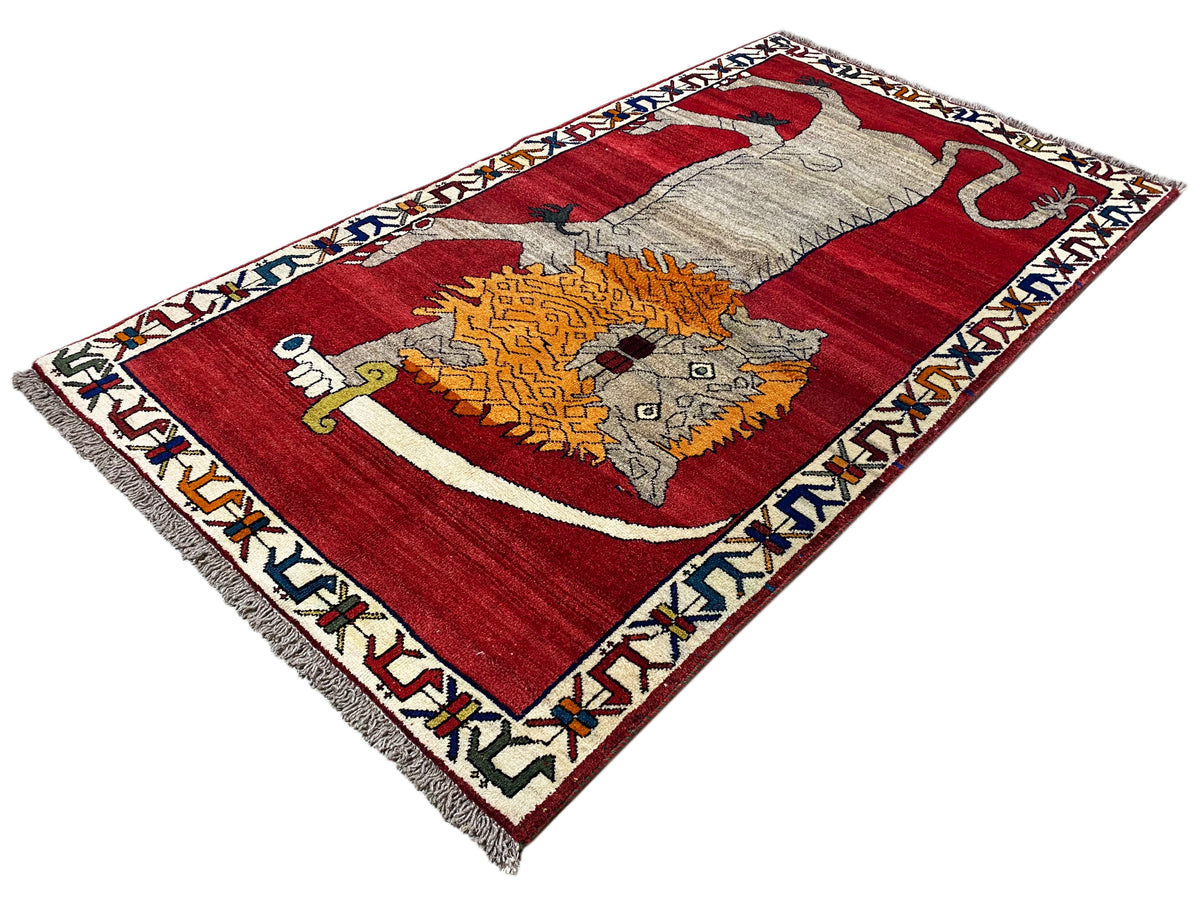 Rug with a red background, white border and central animal motif in gray and orange
