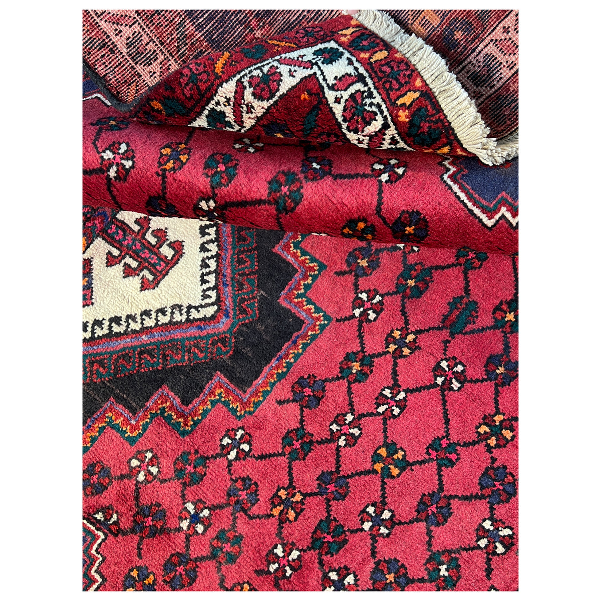 Close-up with pile and borders: red pattern, dark areas, and wrapped edge