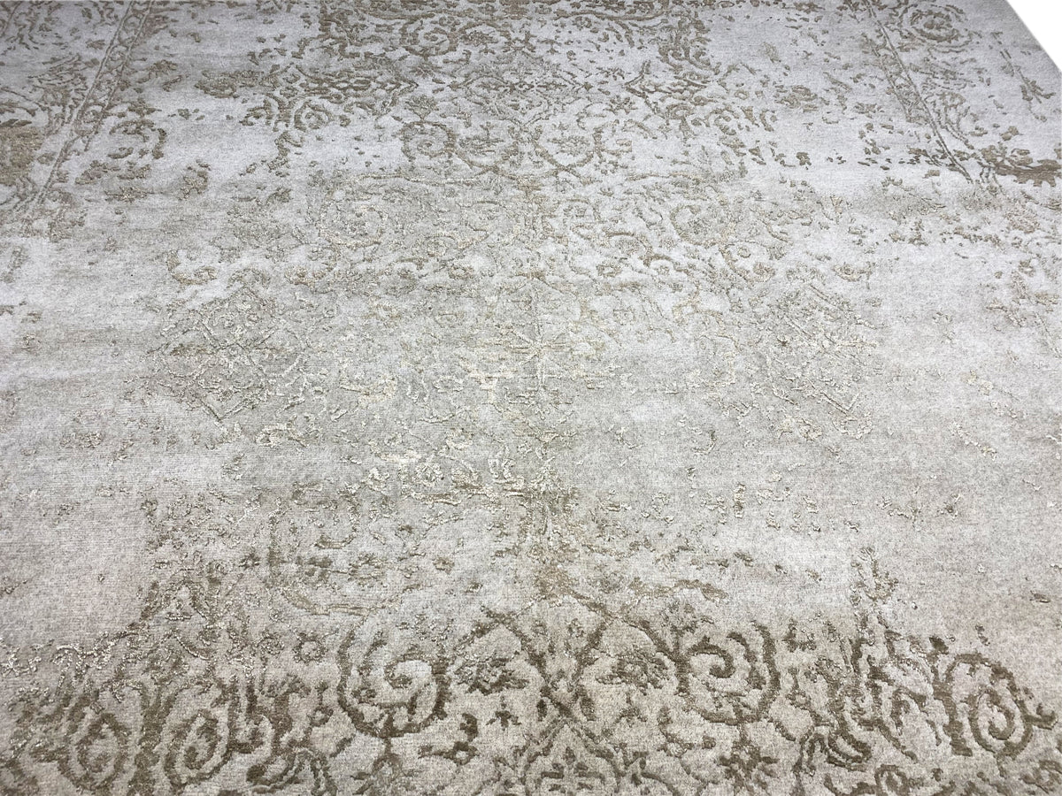 Close-up of a designer rug: light beige surface with subtle vintage-style ornamental texture