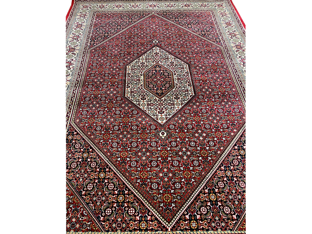 Detail of the red ornamental rug with a central medallion and diagonal borders