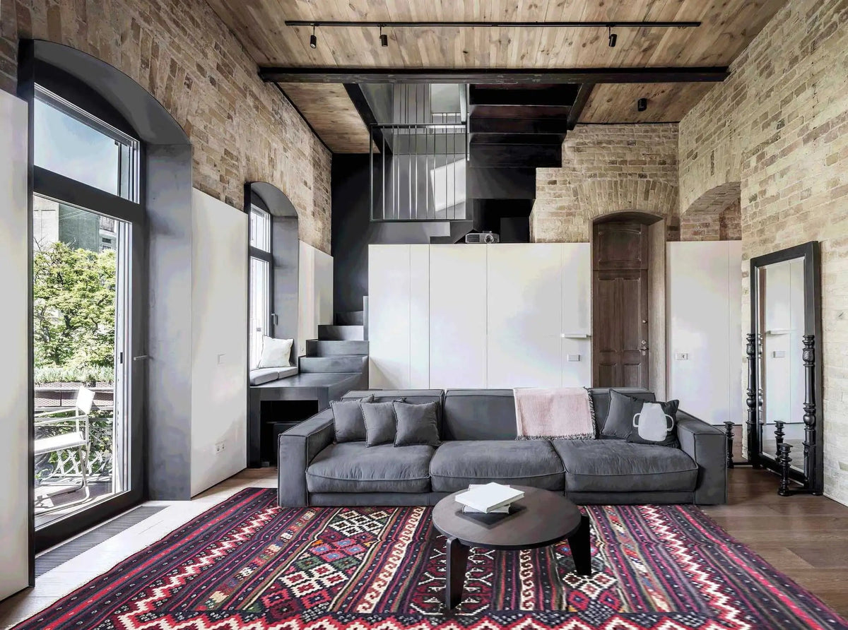 Kilim rug on the floor with a geometric pattern, dark blue, red, and multicolored stripes