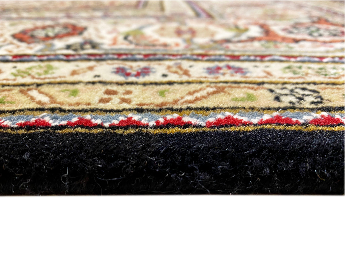Brown Indo-Tabriz rug detail: pile height and black edge with colored border