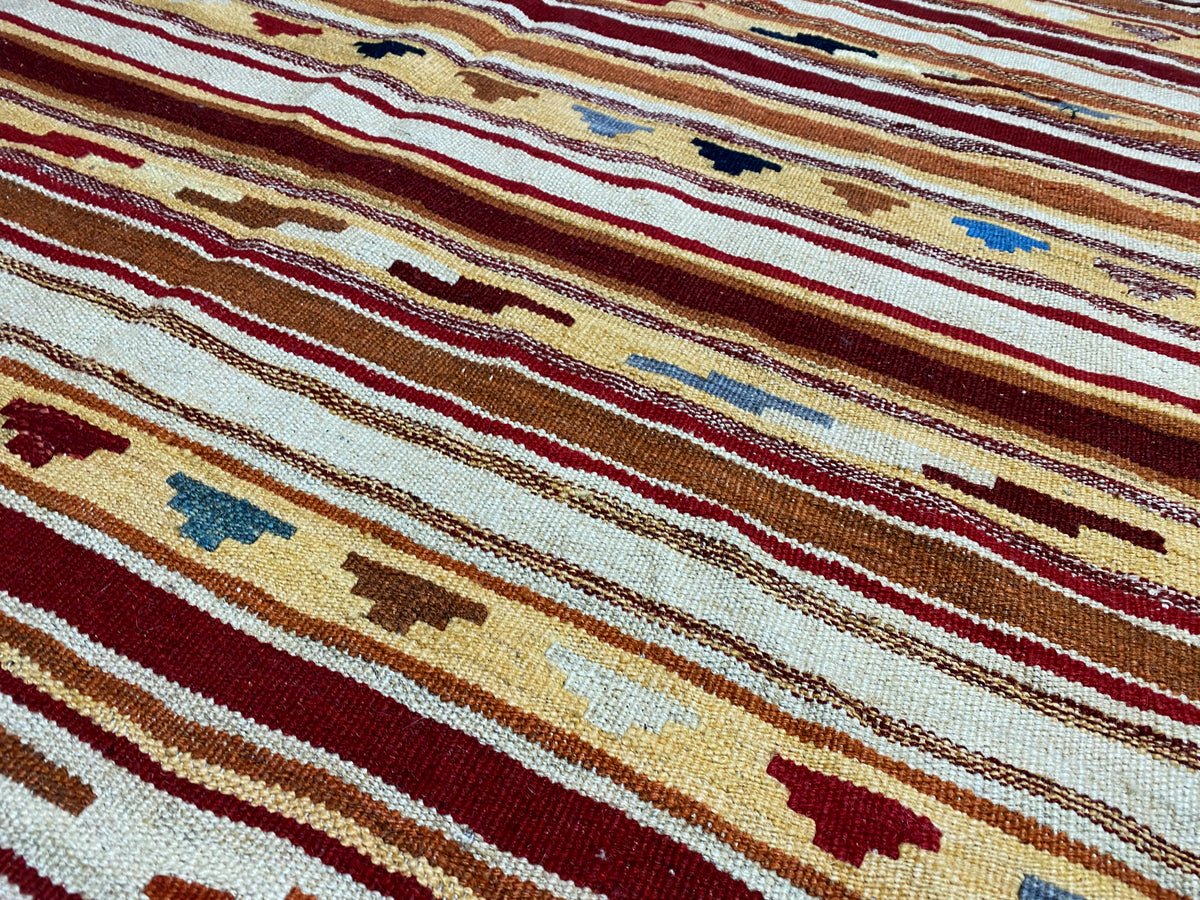 Kilim rug detail view: narrow stripes, small figurative motifs, multicolored wool